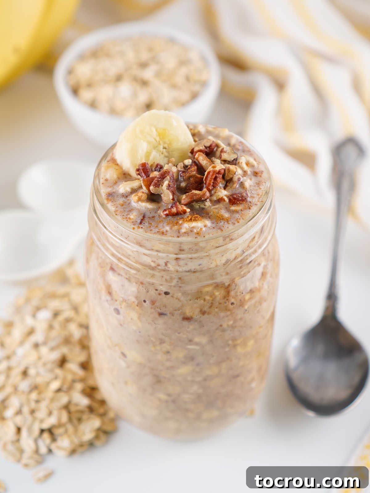 Overnight Banana Bread Bliss 6 Jar of banana bread overnight oats with spoon, ready for breakfast.