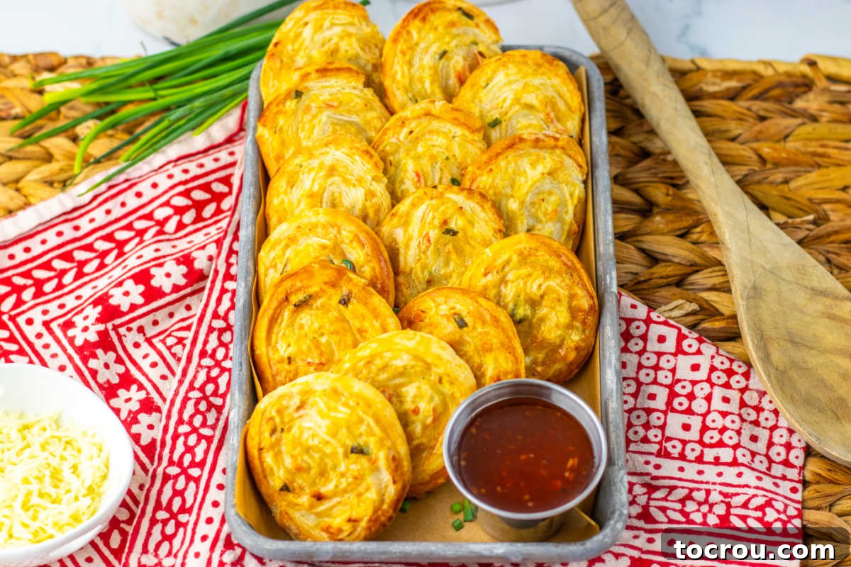 Tray of puff pastry crab rangoon pinwheels with imitation crab and cheese filling, ready to eat.