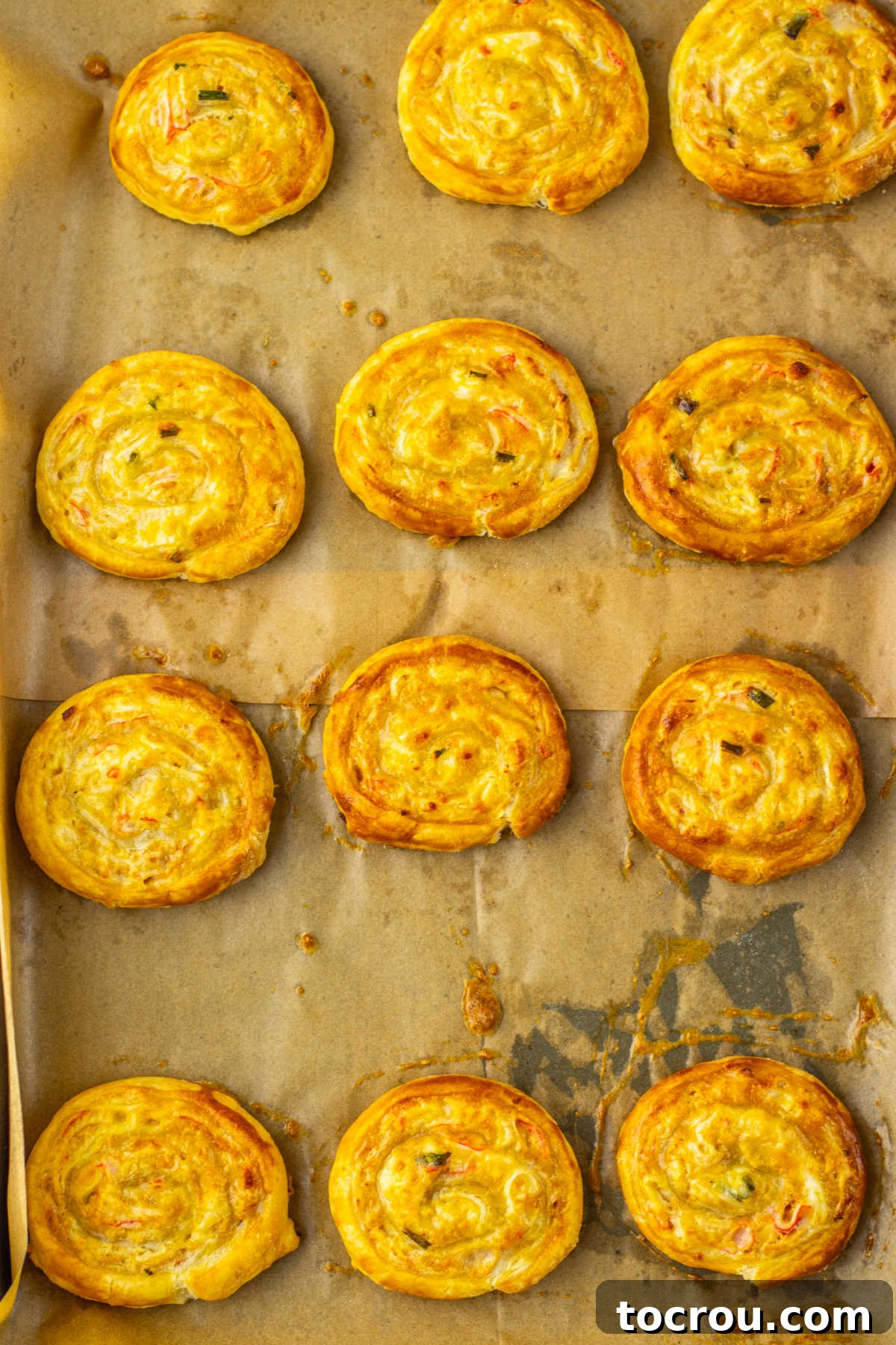 Tray of golden brown crab rangoon pinwheels fresh from the oven.