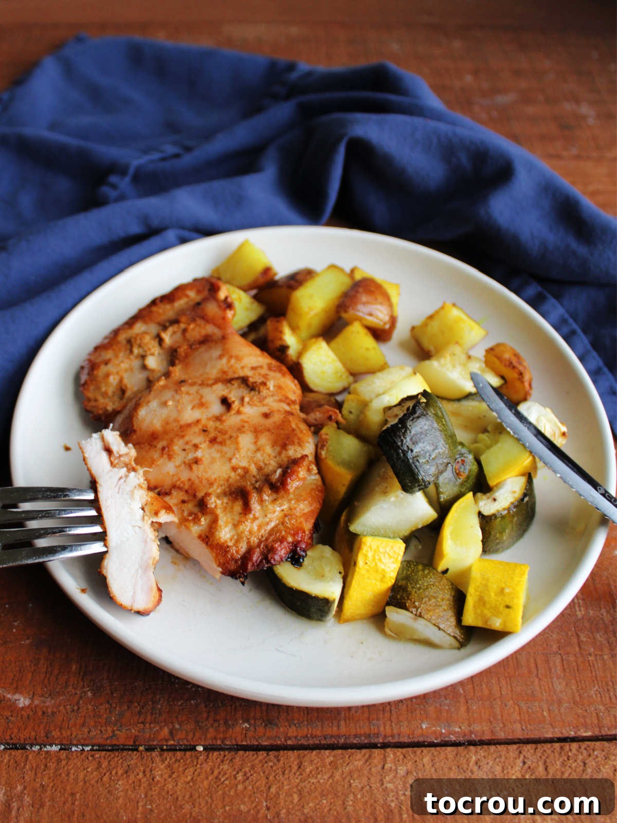 Bite of tandoori chicken  on fork showing juicy interior, ready to eat. 