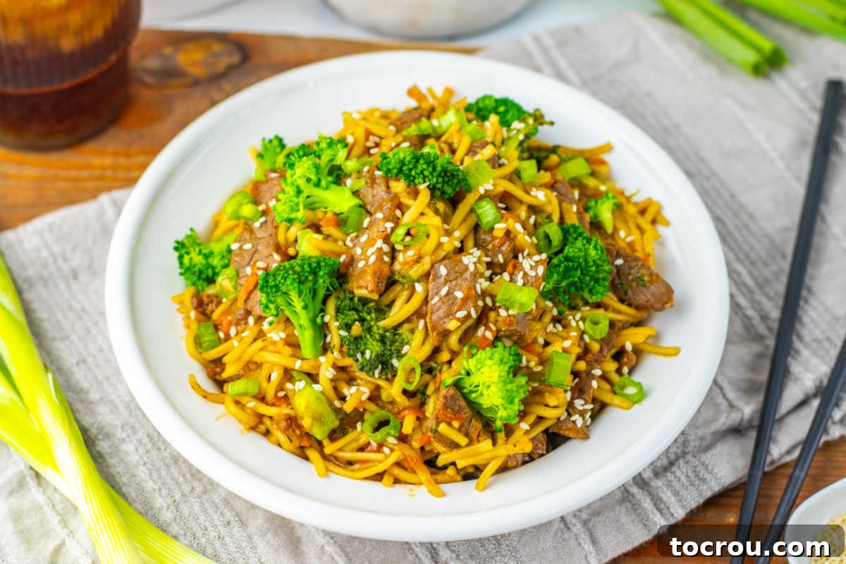 Delicious Beef and Broccoli Lo Mein Plate of homemade beef and broccoli lo mein with chop sticks, ready for dinner.