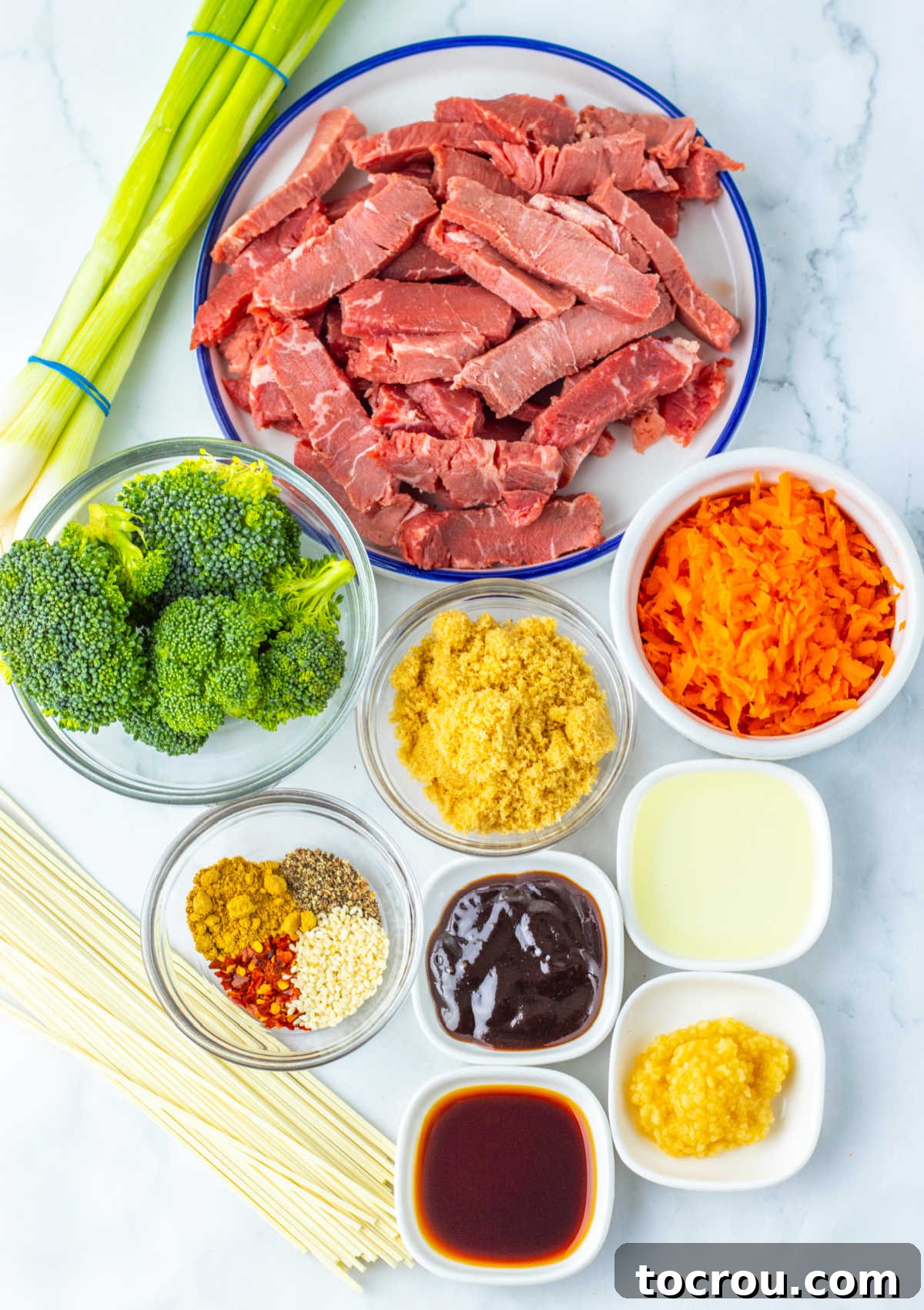 Beef and Broccoli Lo Mein Ingredients Ingredients including sliced steak, broccoli, carrots, ginger, soy sauce, hoisin sauce, garlic, scallions, lo mein noodles and seasonings ready to be made into beef and broccoli lo mein.