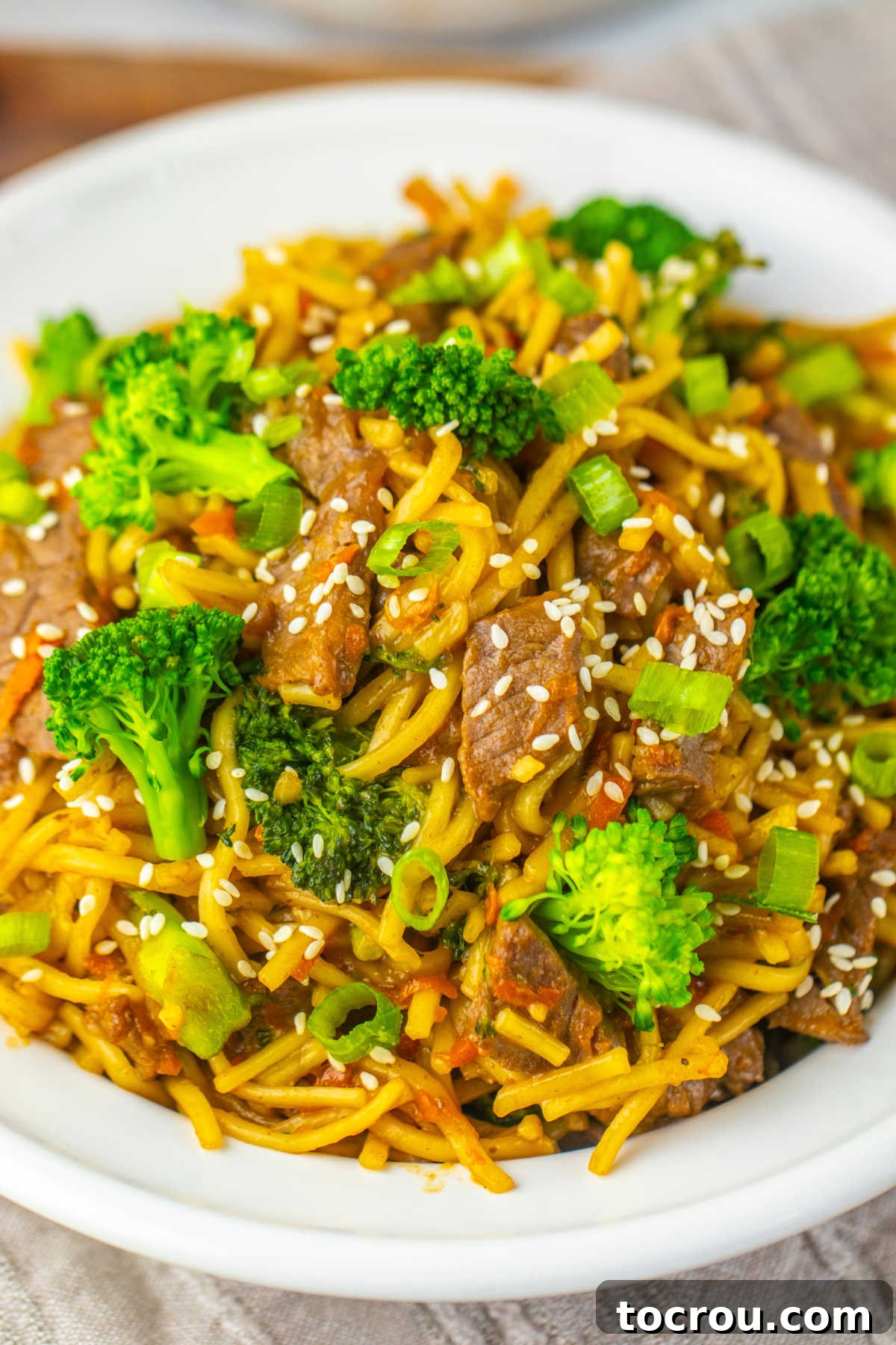 Close-up of Beef and Broccoli Lo Mein Close up of beef and broccoli lo mein showing strips of beef and chunks of broccoli with sauce soaked noodles.