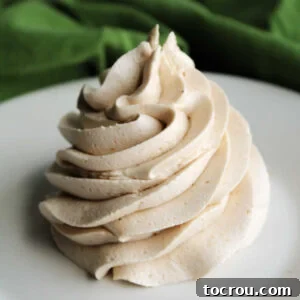 A large piped swirl of creamy apple butter buttercream frosting, showcasing its smooth texture and rich, inviting color.