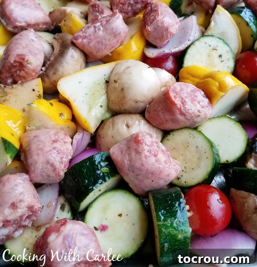 One-Pan Italian Sausage and Roasted Vegetables 4 Sheet pan filled with marinated vegetables and Italian sausage, ready to cook.