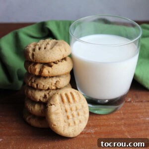 Stack of thick peanut butter sourdough cookies next to a glass of milk.