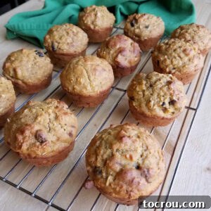 Freshly baked fall harvest pumpkin sourdough muffins with visible fruit pieces cooling on a wire rack.