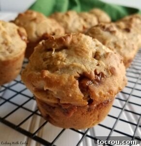 Close-up of a warm caramel apple sourdough muffin on a cooling rack, showing melted caramel glaze and a soft, inviting texture.