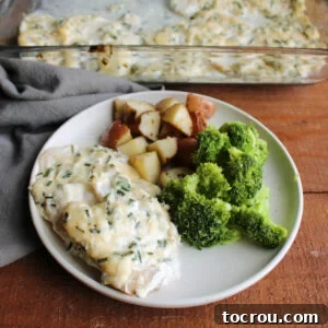 Dinner plate with cream parmesan baked cod served with steamed broccoli and roasted potatoes.
