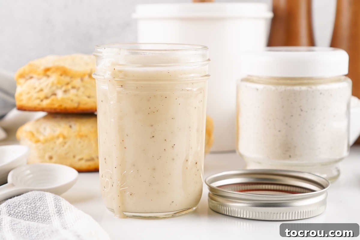 Jar of homemade milk gravy next to the jar of homemade mix it was made from.