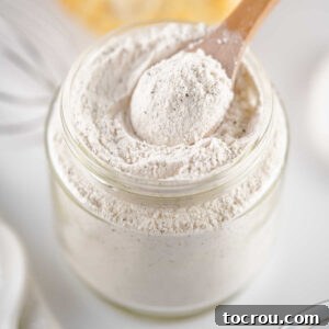 Spoon getting a scoop of homemade white gravy mix out of the jar.