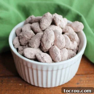 Small bowl filled with almonds coated in dark chocolate and dusted in a mocha mixture, ready to eat.