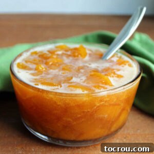 Glass bowl filled with homemade peach sauce ready to go on ice cream, pancakes, waffles and more.