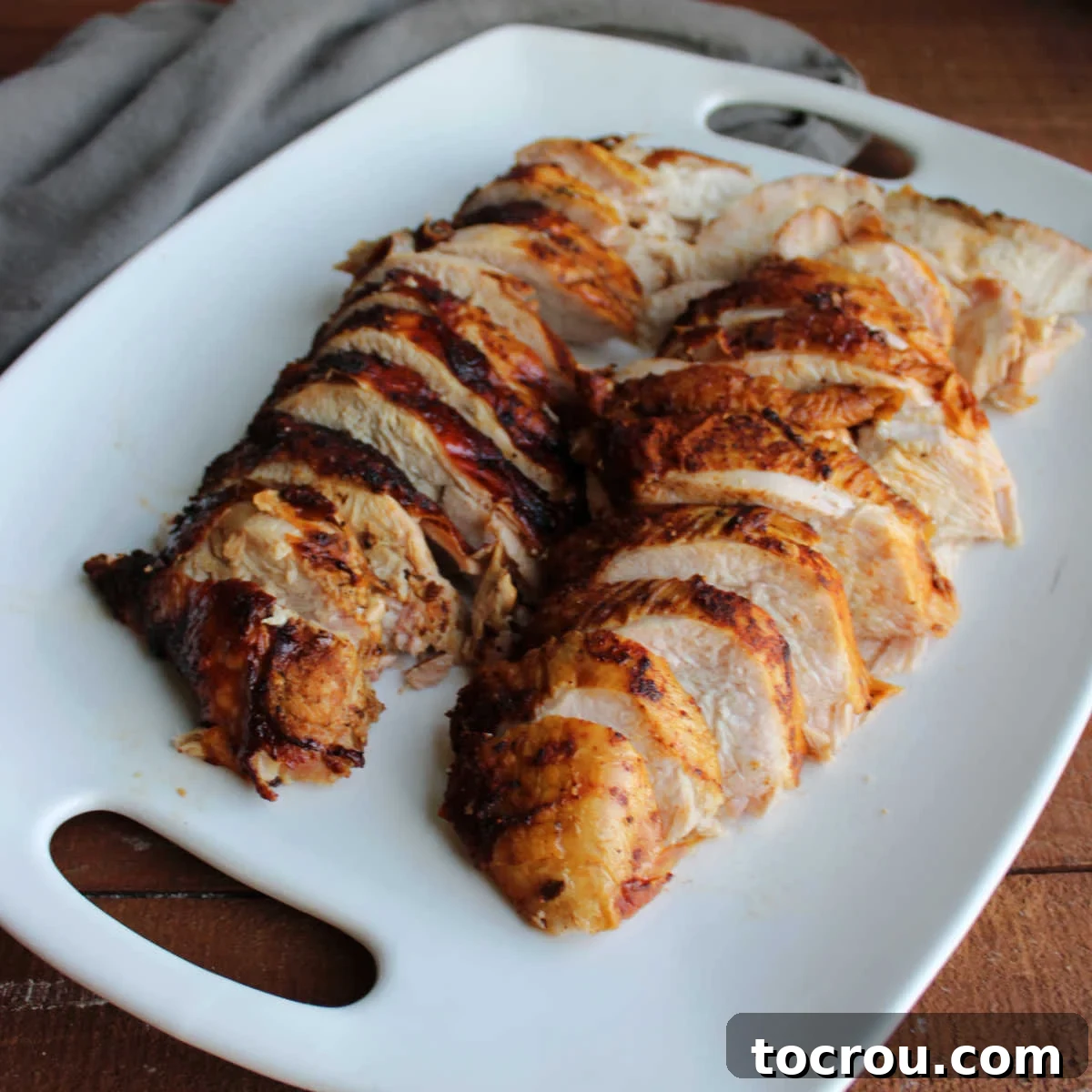 Slices of smoked turkey breast on large serving platter.