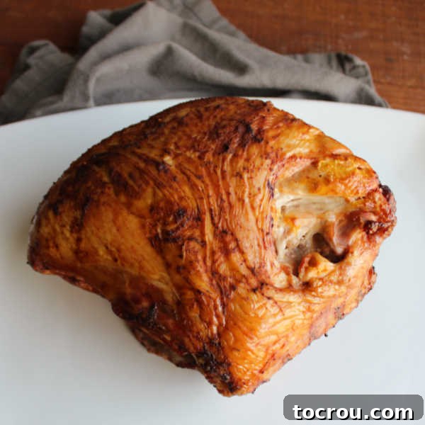 Smoked turkey breast on platter, ready to be sliced.