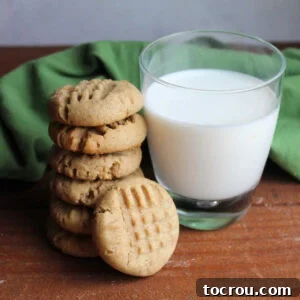 Stack of thick peanut butter sourdough cookies next to a glass of milk.