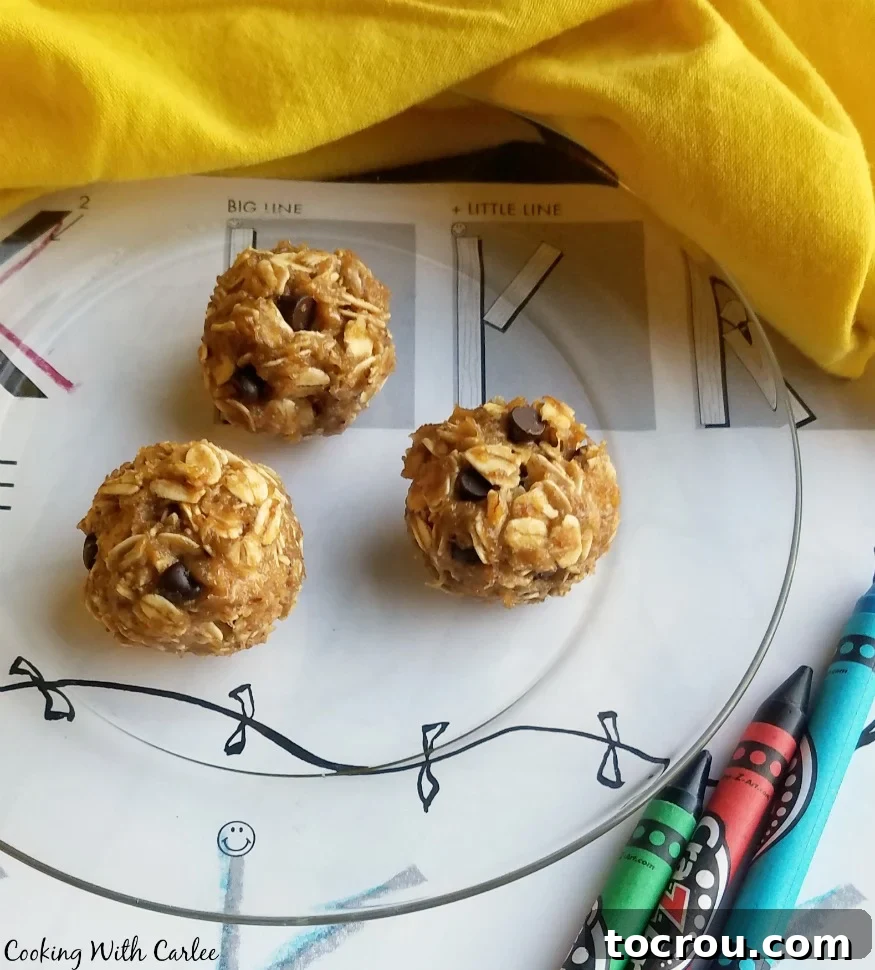 The peanut butter, banana and honey oatmeal balls with chocolate chips on glass plate next to coloring sheet and crayons.