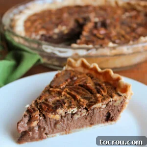 Piece of fudgy chocolate condensed milk pecan pie on plate, ready to eat.