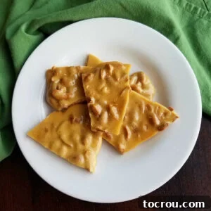 Heirloom Holiday Baking: From Grandma's Cookbook 11 A charming plate laden with irregular pieces of golden, crunchy easy microwave peanut brittle, ready to be enjoyed.