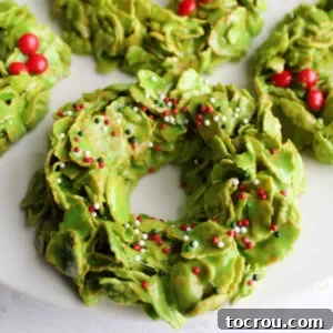 Heirloom Holiday Baking: From Grandma's Cookbook 13 A vibrant close-up of classic corn flake wreath cookies, beautifully adorned with festive Christmas sprinkles and tiny red hots, ready to celebrate the season.