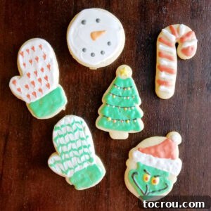 Heirloom Holiday Baking: From Grandma's Cookbook 14 Beautifully decorated sugar cookies, expertly rolled and cut into charming Christmas shapes, each adorned with intricate royal icing designs.