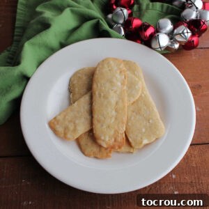 Heirloom Holiday Baking: From Grandma's Cookbook 3 A tempting plate of thin almond icebox cookies, showcasing their light golden-brown edges and crisp, buttery texture, perfect for a classic holiday treat.