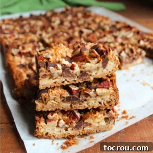 Heirloom Holiday Baking: From Grandma's Cookbook 23 A delightful stack of Magic cookie bars, showcasing a golden graham cracker crumb crust topped generously with sweet coconut, crunchy pecans, and rich chocolate chips, all perfectly baked and ready to enjoy.