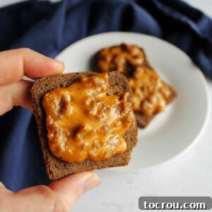 Heirloom Holiday Baking: From Grandma's Cookbook 8 A hand holding a perfectly baked pizza-flavored party rye appetizer, showcasing its golden crust and delicious toppings, ready to be enjoyed as a festive bite.