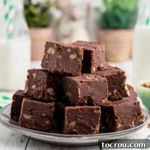 Heirloom Holiday Baking: From Grandma's Cookbook 9 A generous plate piled high with squares of decadent chocolate fudge, revealing delightful bits of walnut within, all perfectly ready to be savored.