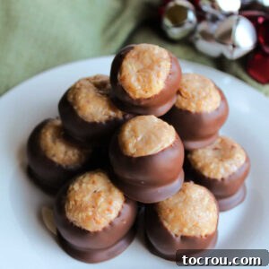 31 Sweet Homemade Treats 11 A stack of caramel peanut balls, showcasing their centers made from tiny bits of peanuts in a caramel mixture, partially dipped in chocolate.