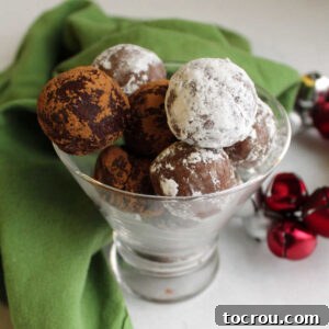 31 Sweet Homemade Treats 20 A stemless martini glass filled with rum balls, lightly dusted with powdered sugar and cocoa powder, ready to be enjoyed.