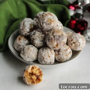 31 Sweet Homemade Treats 3 Small bowl of classic date balls coated in powdered sugar, with one having a bite missing, showcasing their soft, sweet interior.