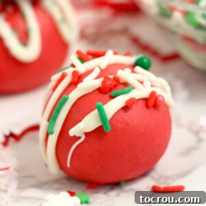 31 Sweet Homemade Treats 27 A close-up of smooth red velvet truffles, adorned with a delicate white chocolate drizzle and festive Christmas sprinkles.