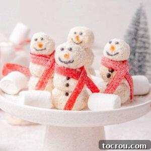 31 Sweet Homemade Treats 10 Homemade coconut candies stacked to resemble snowmen with chocolate decorations and red candy scarves, arranged on a cake stand with marshmallows.