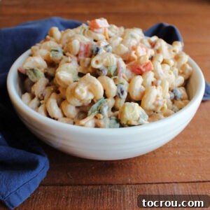 Serving bowl filled with bbq ranch macaroni salad with black beans, tomatoes, corn and more.