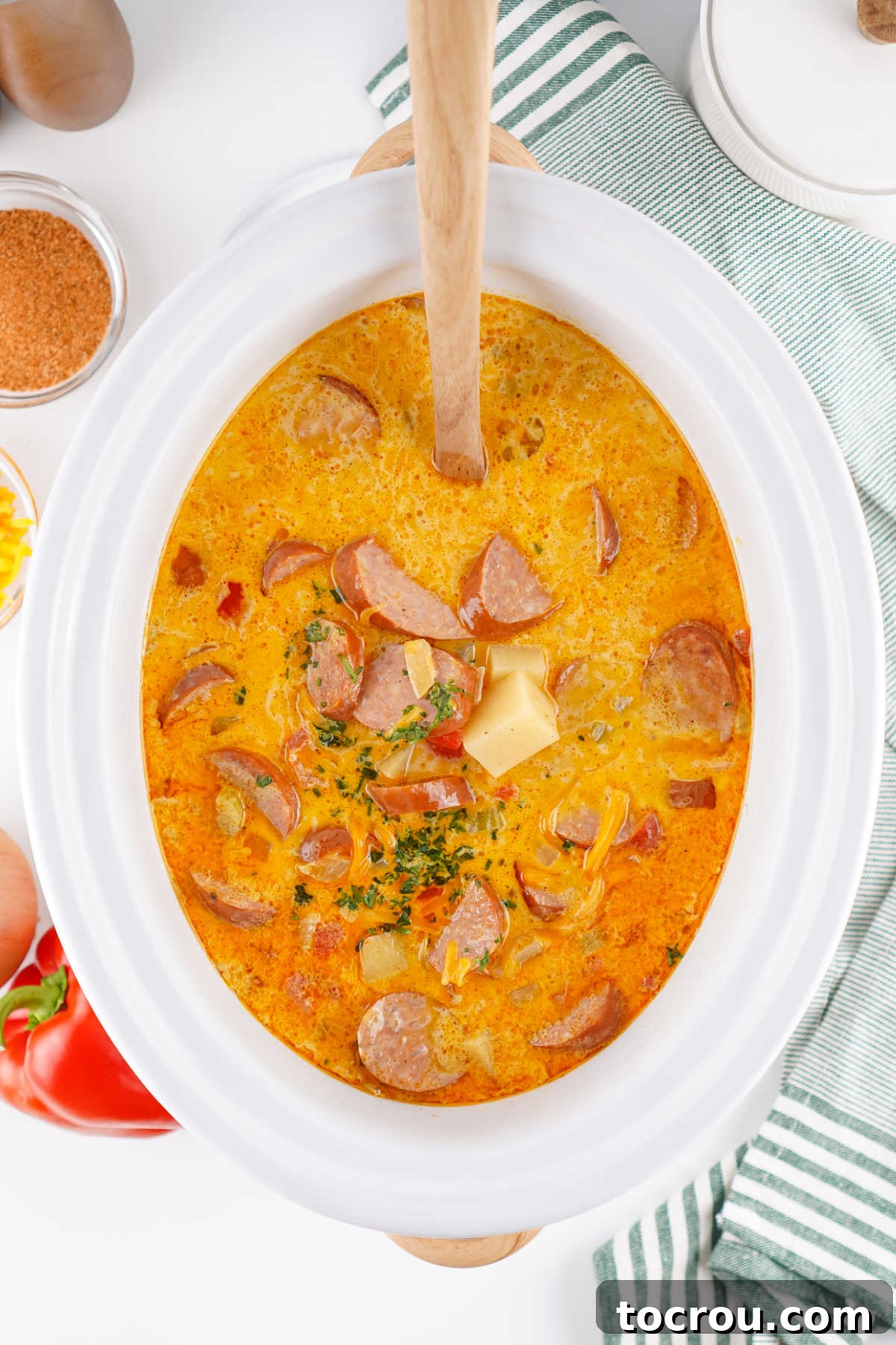 Crockpot full of creamy Cajun potato soup with andouille sausage and the holy trinity. 