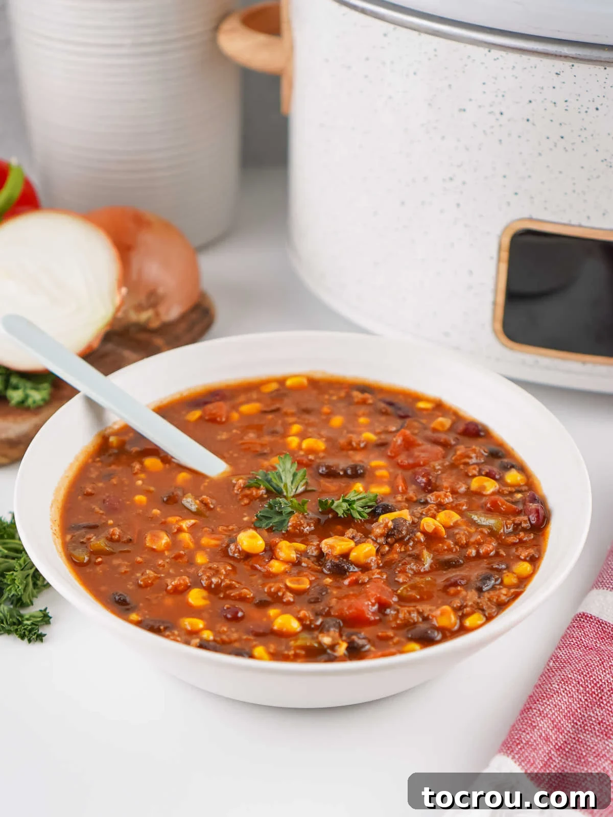 A inviting bowl of slow-cooked Cowboy Soup, featuring visible corn, beans, ground beef, and vegetables in a rich, ready-to-eat broth.