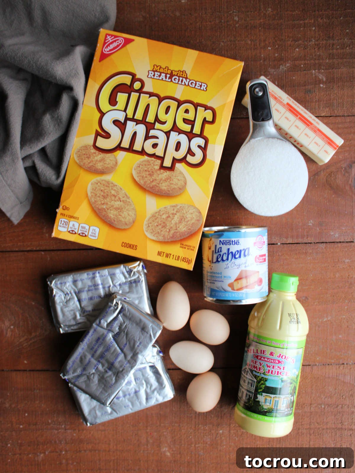 Gather Your Key Lime Cheesecake Ingredients All the essential ingredients for Key Lime Cheesecake: gingersnap cookies, melted butter, granulated sugar, softened cream cheese, large eggs, sweetened condensed milk, and vibrant Key lime juice.
