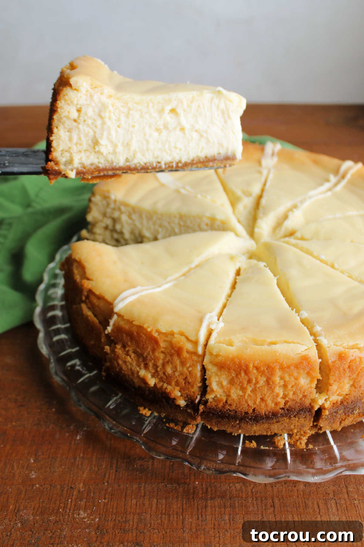 Serving a Slice of Key Lime Cheesecake A serving spatula effortlessly lifts a slice of creamy Key Lime Cheesecake from the platter, showcasing its smooth texture and perfect crust.