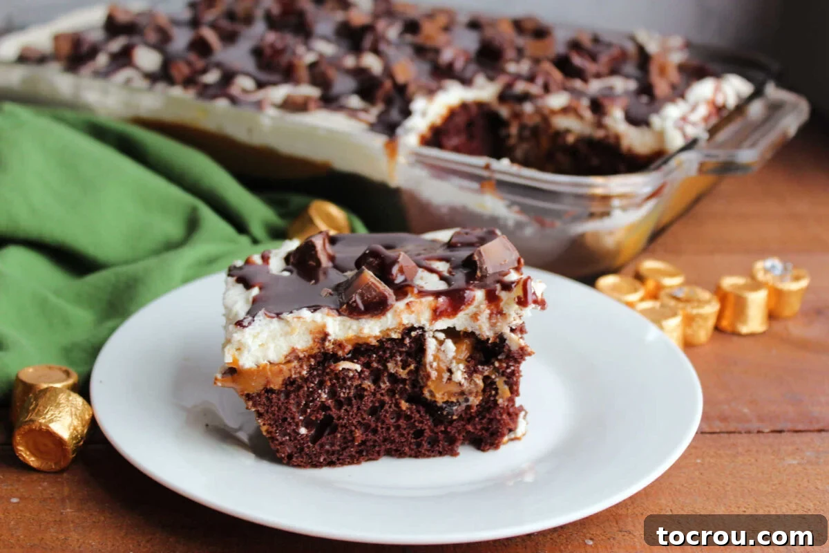 A delectable slice of Rolo poke cake, showcasing layers of moist chocolate cake, golden caramel seeping through, fluffy whipped frosting, scattered Rolo candy pieces, and a glossy fudge drizzle, ready to be savored.
