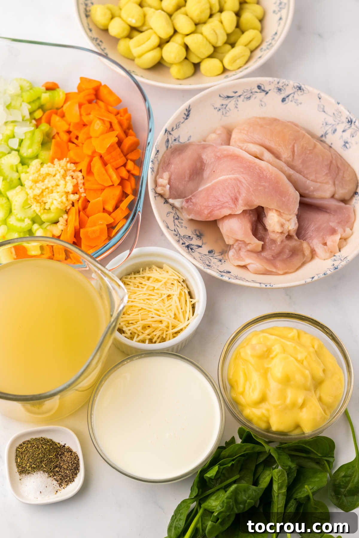 Crockpot Chicken Gnocchi Soup Ingredients Ingredients for slow cooker chicken gnocchi soup laid out: gnocchi, chicken, cream of chicken soup, heavy cream, chicken broth, celery, carrots, garlic, fresh spinach, salt, and pepper.