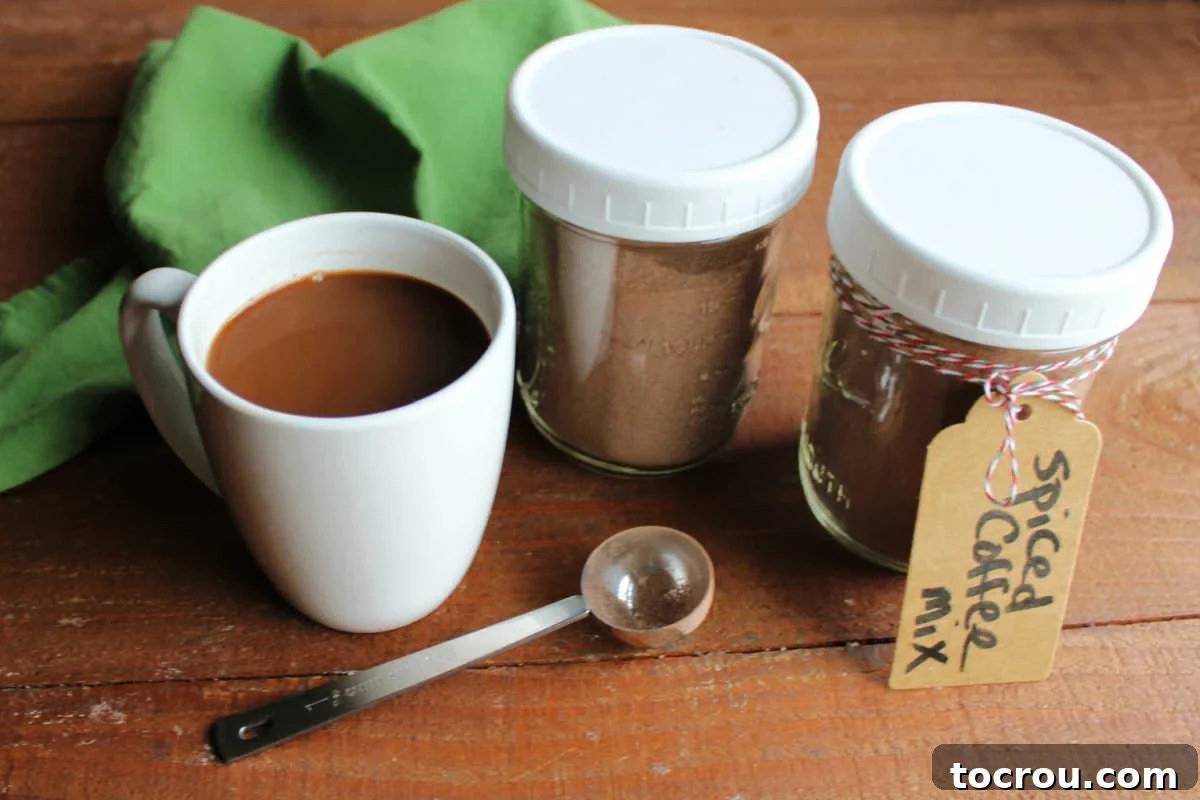Two jars of spiced Christmas coffee mix powder next to a mug of Christmas coffee that is ready to drink. 