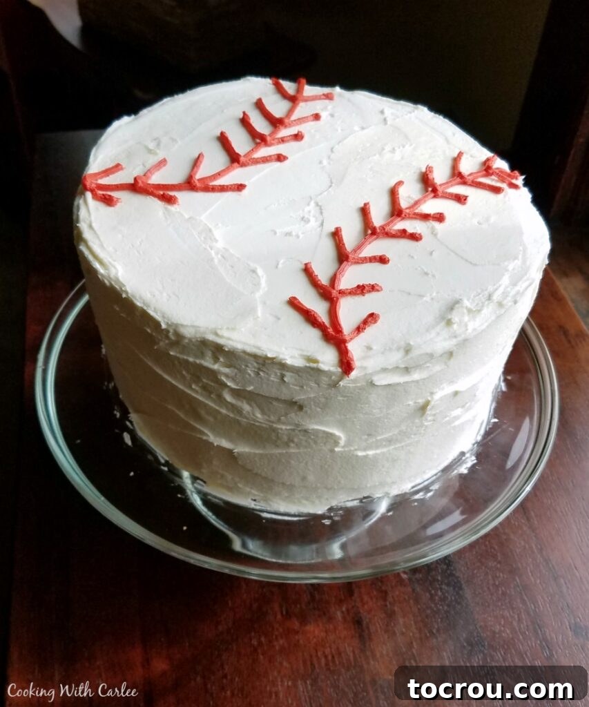 This versatile cake recipe can be easily adapted for various frosting styles and creative themes. A perfectly round layer cake, iced with smooth white chocolate buttercream and intricately decorated with red laces to resemble a baseball, ideal for a sports-themed party.