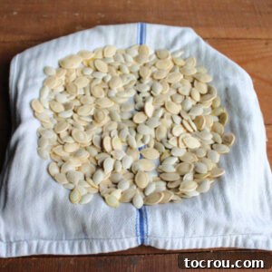 Cleaned pumpkin seeds drying on a tea towel.