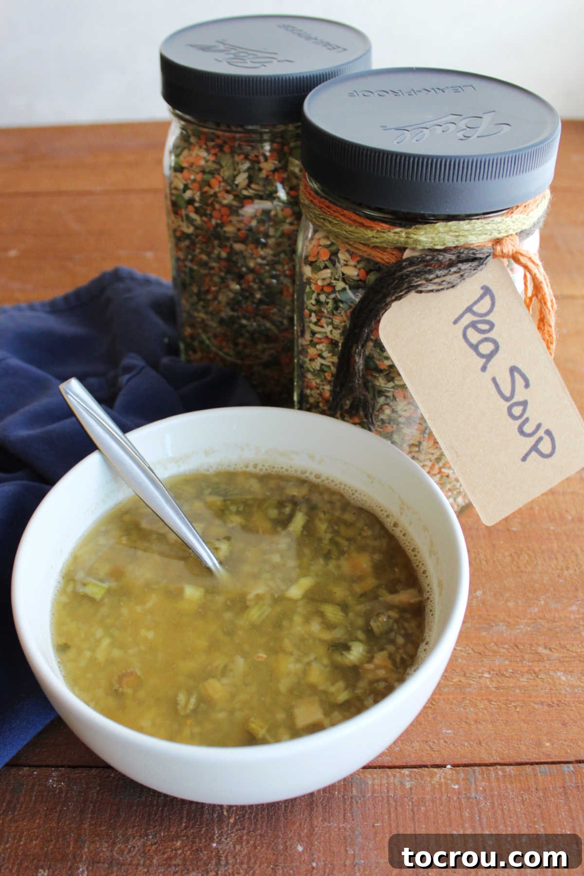 Ready-to-Cook Soup Mix and Cooked Soup A freshly made, steaming bowl of pea soup, rich with legumes and barley, sits invitingly next to two identical jars filled with the homemade pea soup mix. This image showcases both the raw ingredients and the delicious end product.