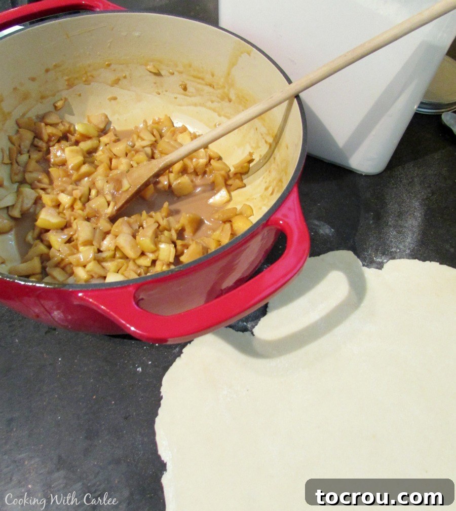 apple and caramel-ly cajeta mixture in pan next to empanada dough.