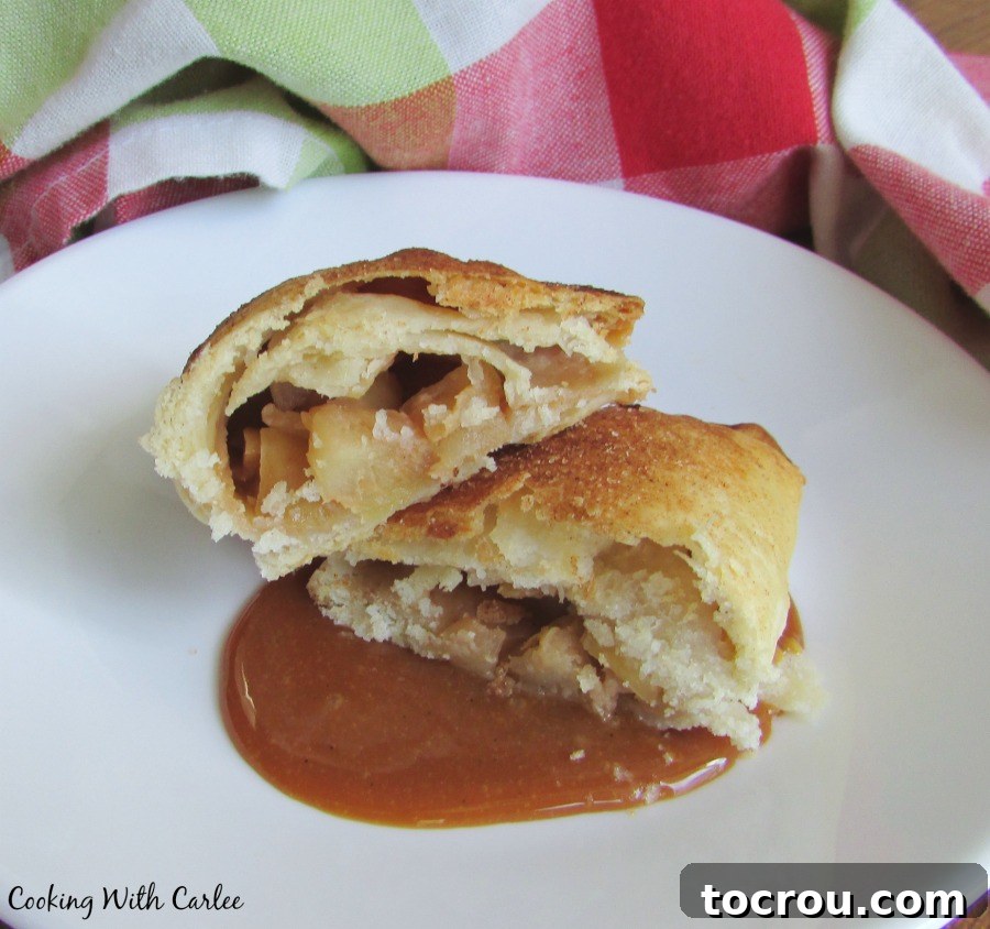 caramel apple empanada cut in half with filling showing sitting on a pool of cajeta.