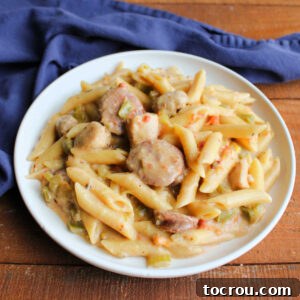 Plate of pastalaya with penne in lightly cheesy sauce with sausage, chicken, peppers, onion, and celery, ready to eat.