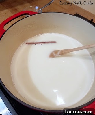 Cajeta Ingredients in a Dutch Oven Enameled Dutch oven filled with fresh goat's milk, sugar, and a cinnamon stick, prepared for slow cooking to transform into Cajeta.