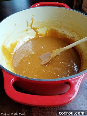 Finished Homemade Cajeta Enameled cast iron pot filled with thick, caramelized goat's milk cajeta, perfectly cooked and ready to be transferred, embodying rich golden hues.